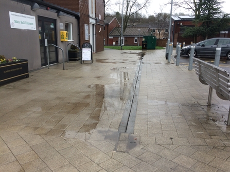 Before DePave: Puddles outside Hollinswood Neighbourhood Centre