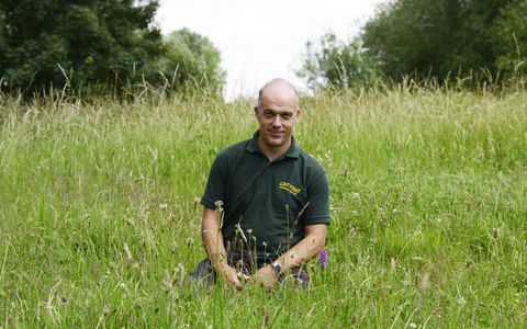 man sitting in field wildlife trust